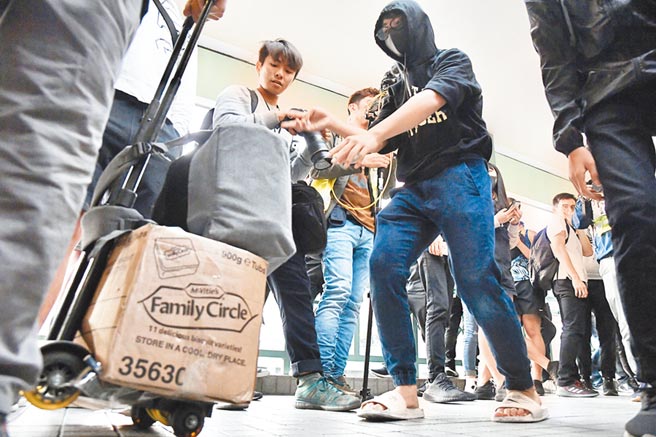 12月28日，有暴徒于上水聚集并于上水广场外天桥骚扰、推撞、辱骂旅客，多名旅客行李及货物被激进示威者扔到地上毁坏，有旅客受到惊慌于港铁站内寻求协助。（中新社／香港中通社图片）