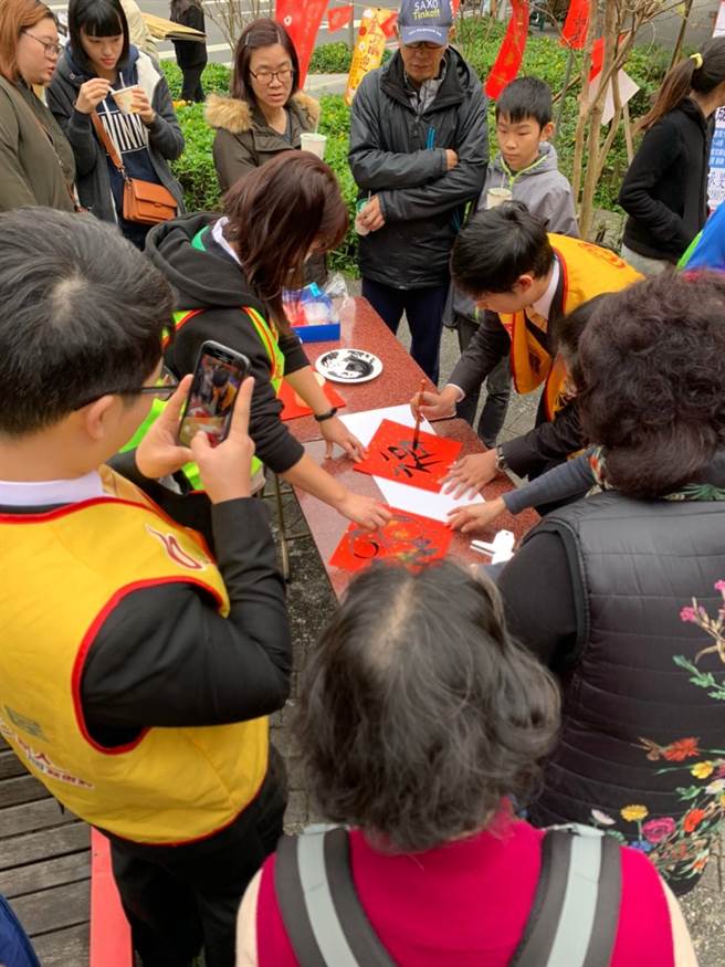 精忠里邀民眾一起写春联，永庆房屋同仁现场也加入挥毫的行列。
