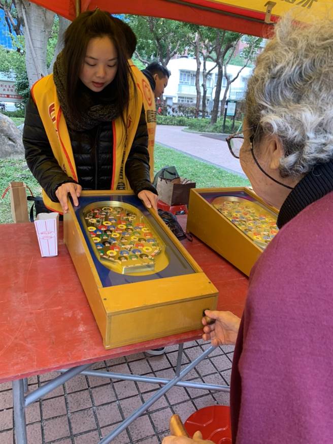 永庆同仁陪伴长辈开心玩弹珠台。