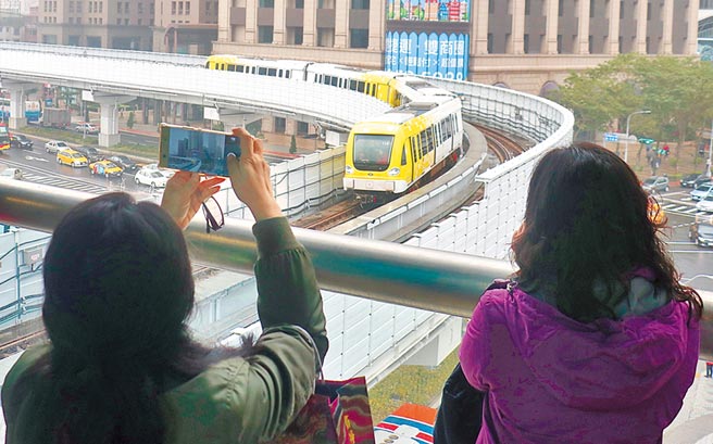 新北捷運環狀線試乘，民眾看見黃白相間的列車，拿起手機猛拍。（實習攝影記者林益民攝）