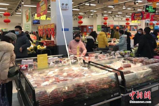 1月23日，武漢市民佩戴口罩，在超市購買生活用品等物資。（中新社）