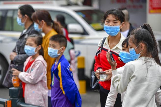 武汉肺炎疫情扩大，连儿童都遭殃，大陆各地民眾都戴起口罩，儿童尤其要做好防护。图为海南海口市。（图／中新社）