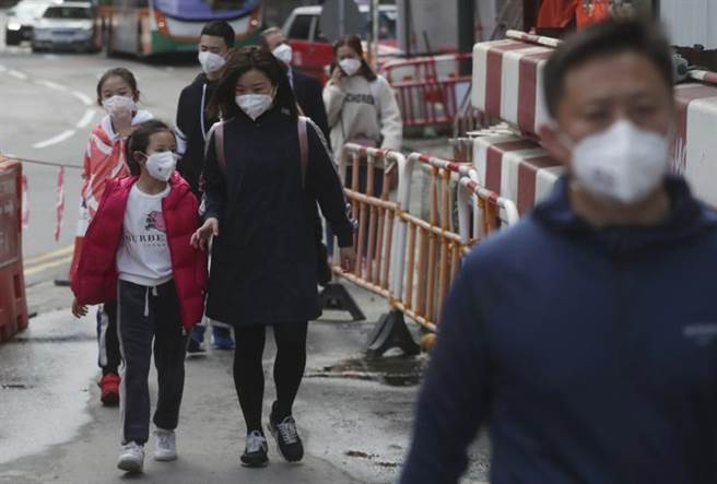 为了防止感染武汉肺炎，游客26日纷纷戴上口罩，走在香港街头。（美联社）