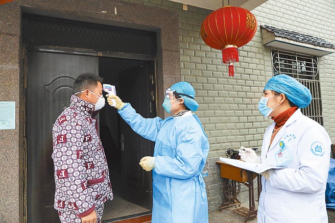 防疫人員在大陸東部浙江省杭州市檢查體溫。（美聯社）