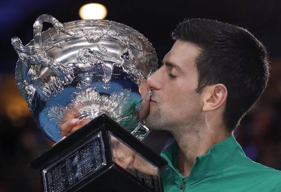 喬柯維奇開心親吻澳網冠軍獎盃慶祝衛冕成功。(美聯社)