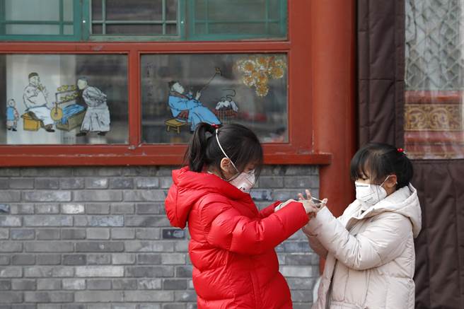 大陸官方對於兒童是否較不易感染武漢肺炎說法一變再變，從不會感染到較不易感染，再改變到較易感染。為保護兒童不受感染，大多數有關兒童的群聚活動都已暫停。圖為北京兩名兒童佩戴著口罩玩耍。（圖／中新社）