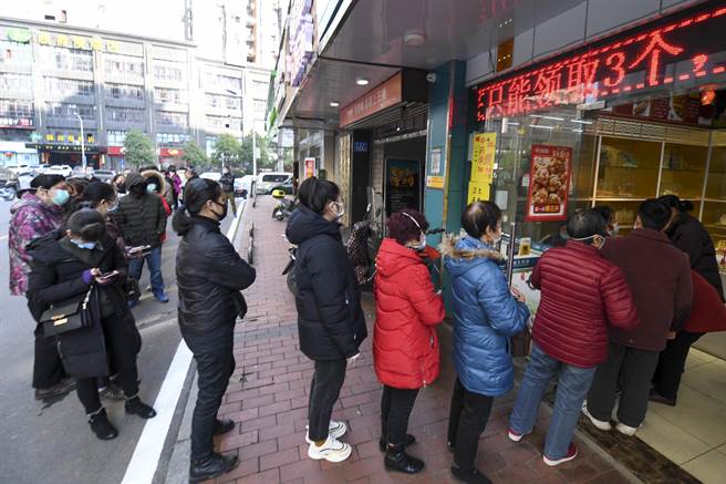 长沙市民在药店前排队，凭身份证可在药店购买到限量的医用口罩。（图／中新社）