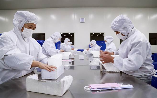 大陆各地口罩工厂赶工生产，仍无法满足民眾需求。图为上海口罩工厂。（图／中新社）