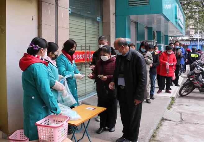 武汉肺炎疫情向全球扩散，口罩成为紧缺物资，民眾排队买口罩，大陆地方政府则是明着抢。图为广西民眾排队买限额口罩。（图／中新社）