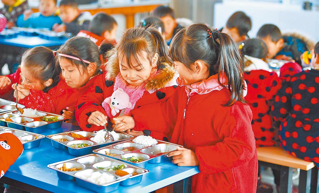 大陸目標2020年將「全面建成小康社會」。圖為安徽舒城縣曉天中心小學學生吃營養午餐。（新華社資料照片）