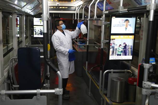 2月10日北京将迎来春节假期后的开工日，北京南站公交站员工2月9日晚为车辆消毒。(中新社）