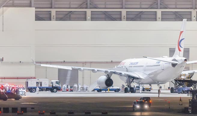 2月3日，东方航空载送的首班武汉返台包机飞抵桃园机场，专案小组全副武装办理检疫消毒与后续入关程序。（本报系资料照片）