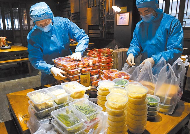 重慶市一家火鍋店的工作人員為顧客打包火鍋外賣。（中新社）