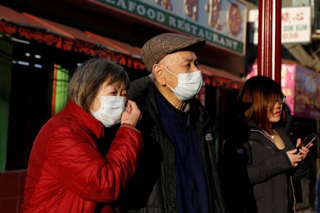 加州旧金山民眾戴口罩行经唐人街的画面。（路透）