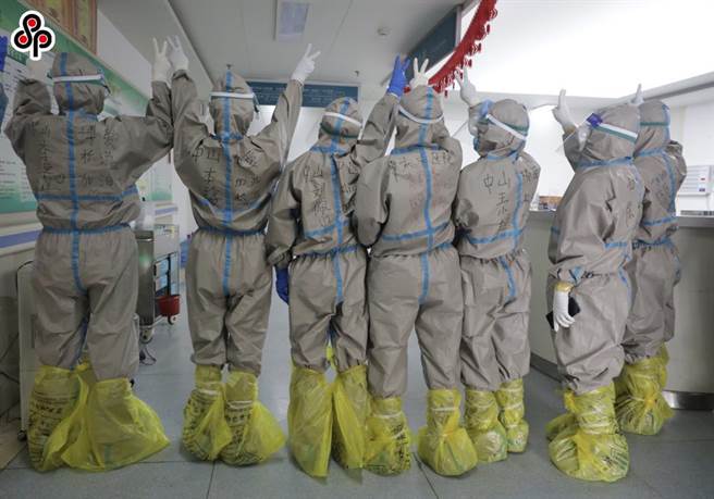 圖為派遣至松滋市人民醫院工作的廣東醫療隊隊員6日在防護服上寫下自己名字。（新華社）