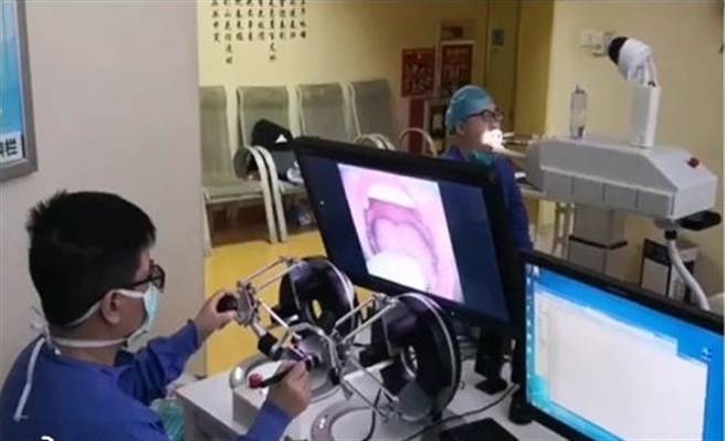 由锺南山院士团队与渖阳自动化研究所联合发起的新型智慧化咽拭子採样机器人系统研发完成，可以避免医护人员在採样过程中被病患感染。（图／央视新闻）