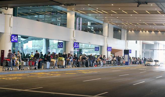 中央疫情指挥中心公告，自19日凌晨0时起，所有入境旅客须居家检疫14天，旅客无亲友接机，只能搭乘防疫计程车，桃园机场清晨起，排队搭乘防疫计程车的入境旅客排队人龙超过上百公尺，挤爆计程车排队区域，搭上车要等待近二小时，桃机防疫车队还请求松山机场车队支援。（陈麒全摄）