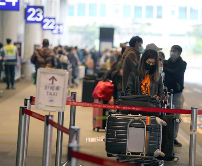 中央疫情指挥中心公告，自19日凌晨0时起，所有入境旅客须居家检疫14天，旅客无亲友接机，只能搭乘防疫计程车，桃园机场清晨起，排队搭乘防疫计程车的入境旅客排队人龙超过上百公尺，挤爆计程车排队区域，搭上车要等待近二小时，桃机防疫车队还请求松山机场车队支援。（陈麒全摄）