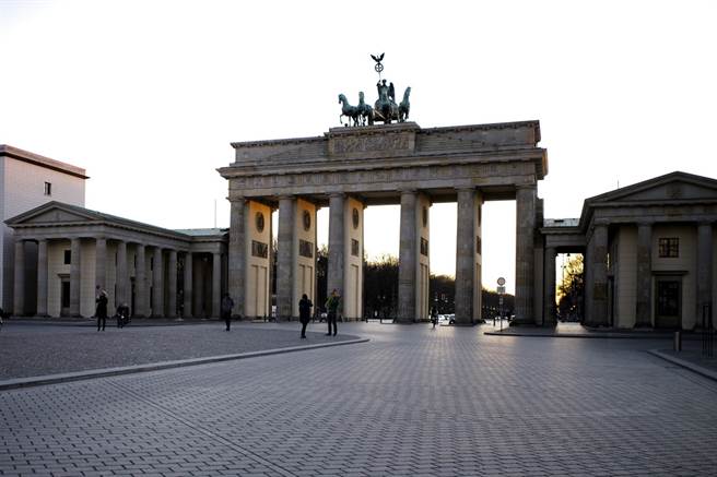 德国新冠肺炎疫情升温，政府呼吁民眾尽量待在家中。图为首都柏林布兰登堡门前一片空荡荡的画面。（图／美联社）
