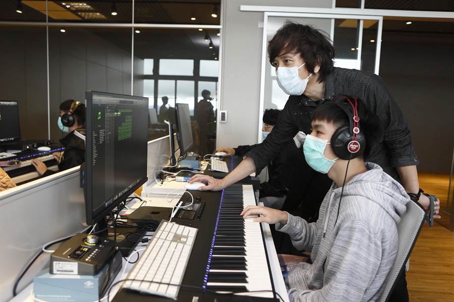 台北城市科技大學流行音樂事業系薛忠銘(右)為學生介紹系上設備。(張鎧乙攝)