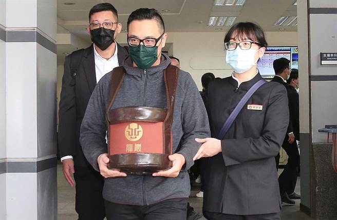 劉真火化完畢，弟弟手捧骨灰罈離開。(粘耿豪攝)