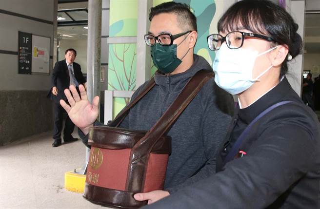 劉真火化完畢，弟弟手捧骨灰罈離開。(粘耿豪攝)