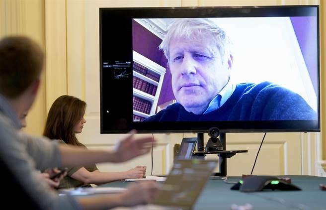 英国首相强森因新冠肺炎确诊，而在唐寧街10号官邸自我隔离，图为他3月28日针对新冠肺炎疫情召开远距会议的画面。（美联社）