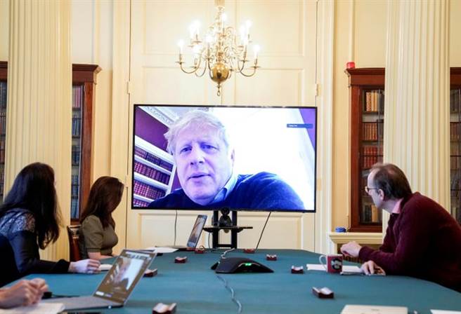 英國首相強森確診後自我隔離，圖為他和閣員進行視訊會議。（路透）