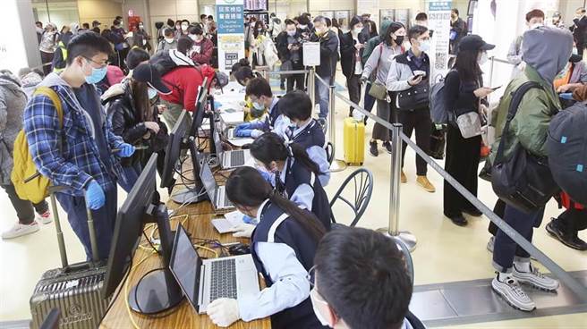 在桃園機場第二航廈入境管制區內，3月20日一群從美國搭機返台的旅客，正在排隊查驗健康聲明書。（資料照片，范揚光攝）