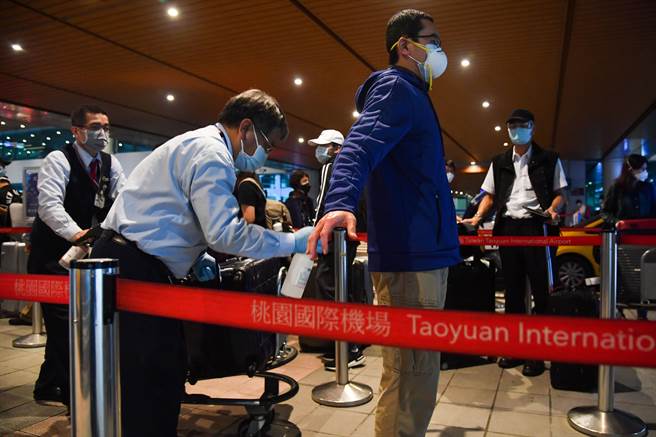 為了加強防控新冠肺炎疫情，台灣防疫車隊除了在桃園國際機消毒行李外，也為旅客進行全身消毒。（中央社）