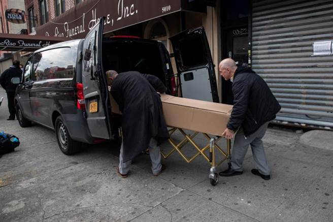 专家认为美国新冠死亡病例数目存在严重漏报问题，有很多死亡患者还来不及检测或是还未住院就已死亡，医务通报系统各州也不太一致，导致真实死亡数据还要很久才能查明。图为纽约市一场葬礼上，工作人员正抬出新冠肺炎死者的棺木。（图／路透）