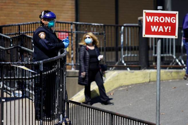 新冠病毒重擊美國。圖為疫情震央紐約市醫院外，警察也戴上保護裝備防止感染病毒。（路透）