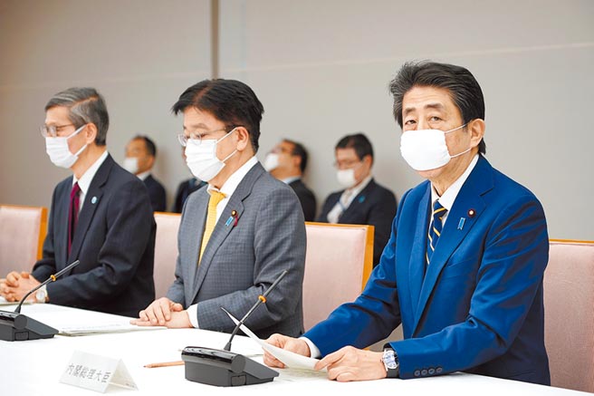 日本首相安倍昨日戴口罩主持内阁会议。安倍正式宣布日本为因应疫情正式进入紧急状态。（美联社）