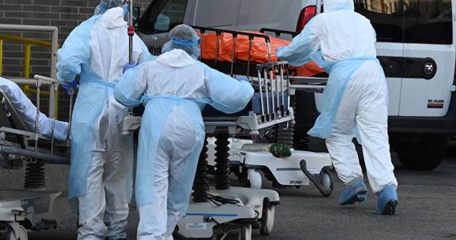 纽约是新冠肺炎疫情的重灾区。图为医护人员接遗体时，身上只套着薄薄的垃圾袋。（达志影像／美联社）