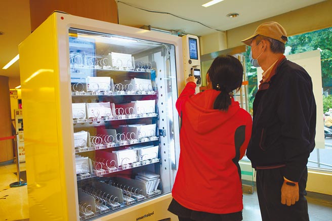 台北市實名制口罩販賣機24日擴大試辦至文山、萬華區健康服務中心，有不少民眾前往嘗鮮購買。（張立勳攝）