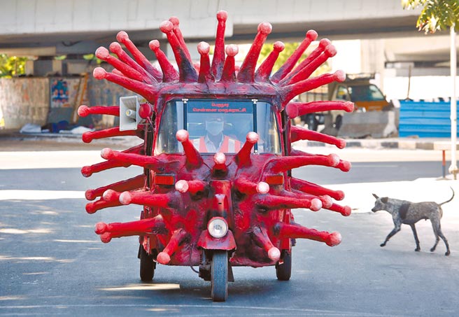 印度一名男子將車輛外觀改造成冠狀病毒的模樣行駛在路上。 （路透）