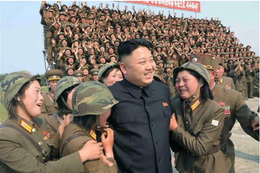 圖為2014年4月金正恩在北韓官媒發布的照片中，被眾女兵團團包圍。當時的金正恩右額頭上似乎沒有看到這道傷痕。(中時資料庫)