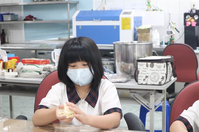 台南麻豆安業國小學生專注得揉著麵糰，期待美味麵包出爐。（李宜杰攝）