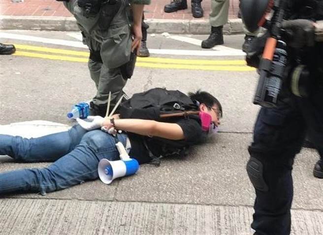 香港中西區區議員葉錦龍參與反國安法遊行，遭警方壓制在地並扣上索帶逮捕。（圖／東網）