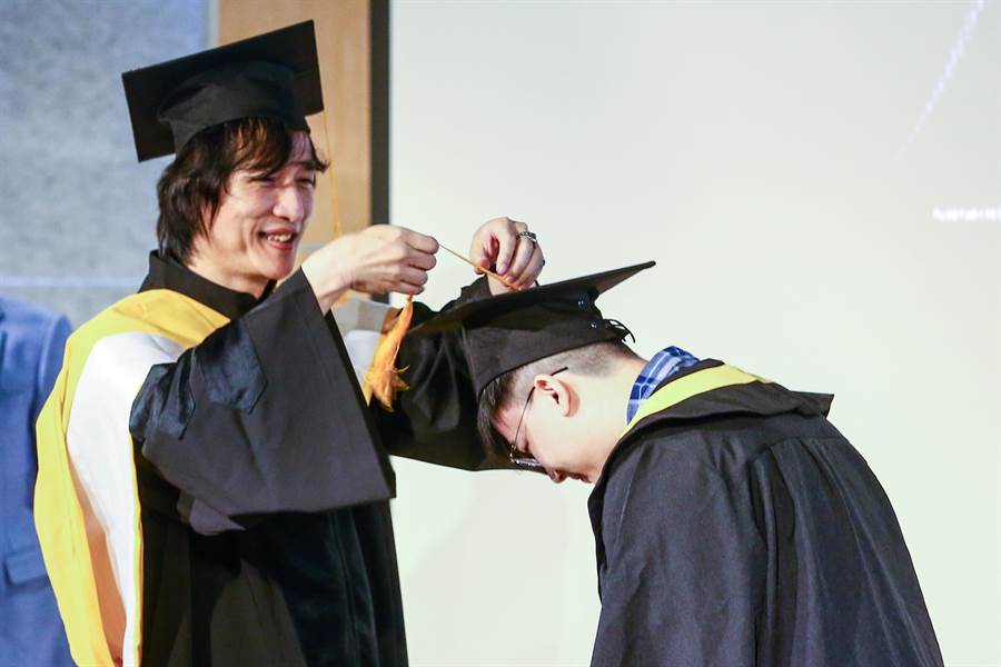 台北城市科大流行音樂事業系主任薛忠銘(左)為畢業生行撥穗禮。(鄧博仁攝)
