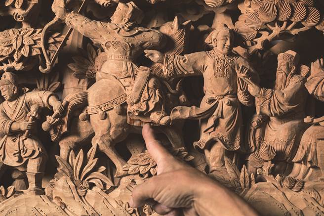 图片上可见左方人物鞋子与右边人物的衣带连接在一块儿，即是「串接牢靠」，用意在不破坏木头结构。（图／翁子恒摄）