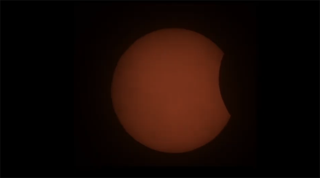 下午3時01分漸漸出現「初虧」，太陽的下右側將逐漸被月面遮掩，出現黑影缺角。(圖擷自氣象局直播畫面)
