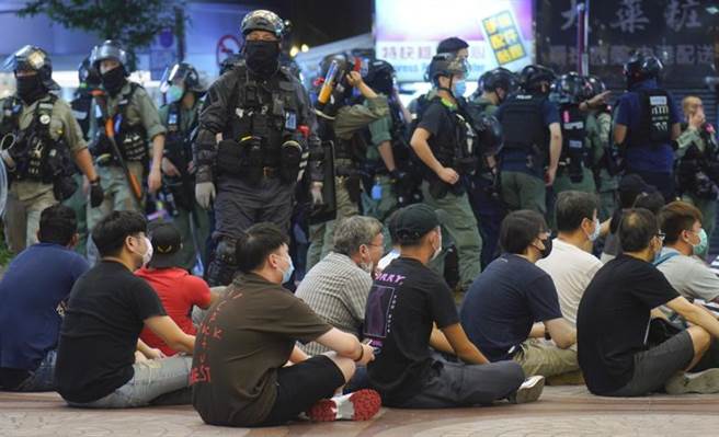 《港區國安法》實施首日有香港網民發動遊行，港警下午對遊行舉旗警告，至晚上8時，已拘捕超過300人，當中9人（5男4女）以涉嫌違反香港《國安法》被捕。（圖／美聯社）