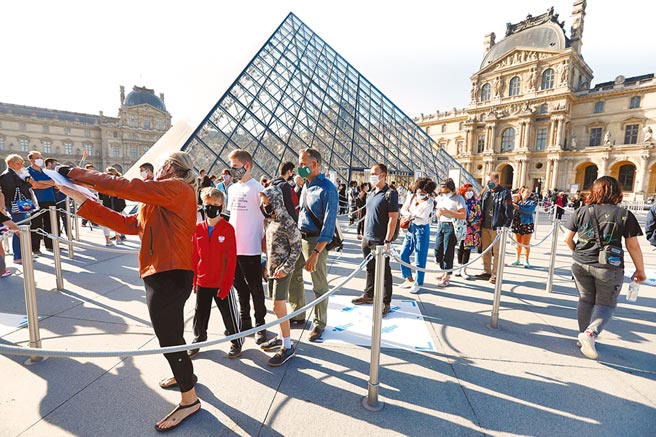 法國巴黎羅浮宮6日部分重啟，遊客被要求戴上口罩，站在地面上的標示位置，與名畫「蒙娜麗莎的微笑」一起自拍。（路透）