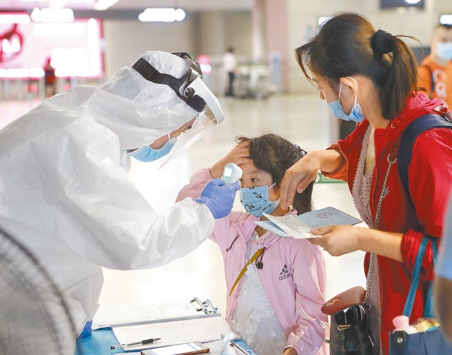 上海虹橋機場防疫人員對小朋友量體溫。（中新社資料照片）