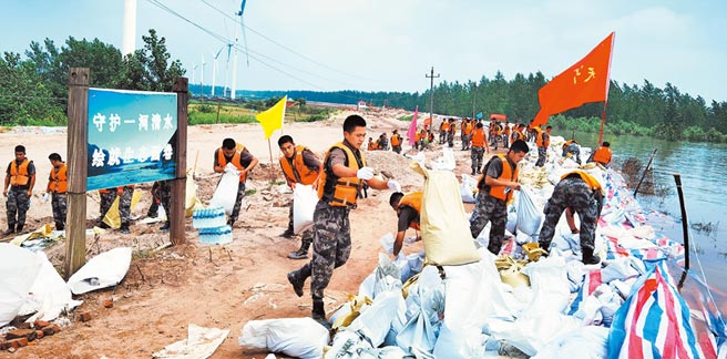 7月14日，解放軍東部戰區官兵火速馳援抗洪一線，加固江西九江市圍堤800多公尺。 （新華社）