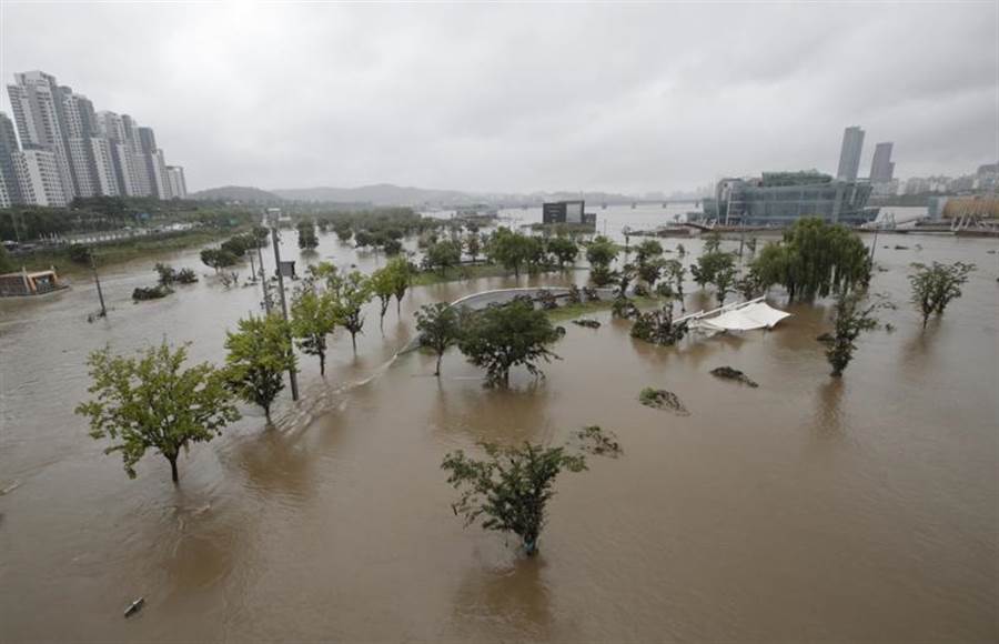 據當局最新統計，自中部地區進入梅雨季迄今，暴雨共造成38人死亡、12人失蹤，釀成9年來最嚴重的水災。圖為漢江氾濫，淹沒首爾市區內的1處公園。(美聯)