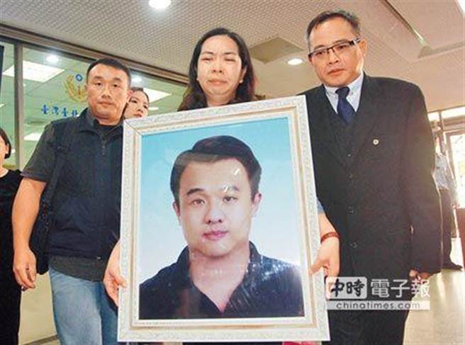 警員薛貞國捧著遺照出庭。資料照片