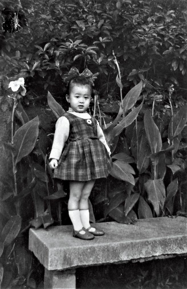 羅霈穎三歲時站在庭院美人蕉前。（羅青提供）