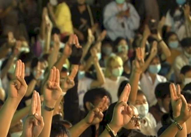 泰國年輕的抗爭者，以電影「飢餓遊戲」的三指手勢，表示自己的反抗精神。(圖/路透社)
